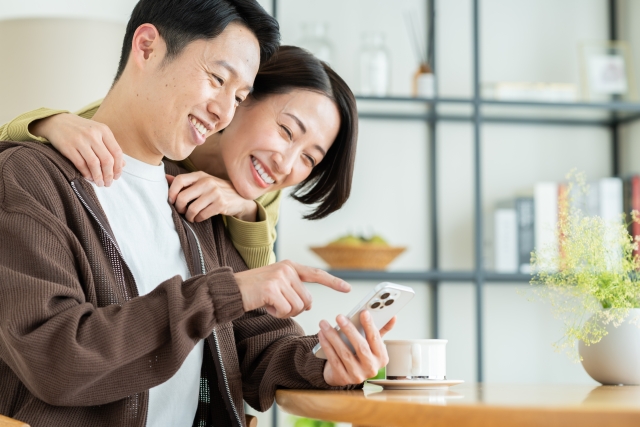 スマホを見つめて幸せそうな男女
